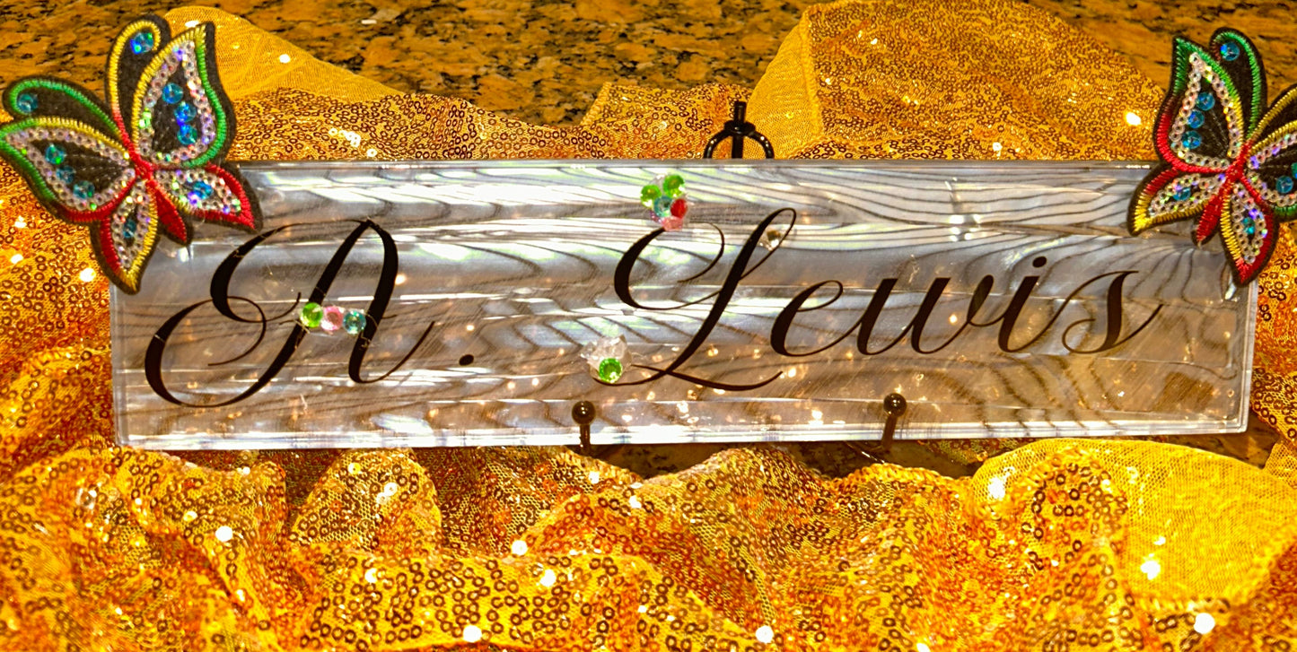 Decorative nameplate with 'R. Lewis' on a gold glittery background with butterflies.