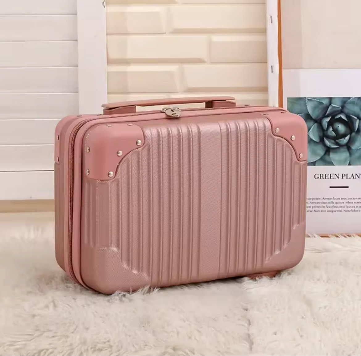 Pink suitcase on a light wooden floor with a magazine in the background