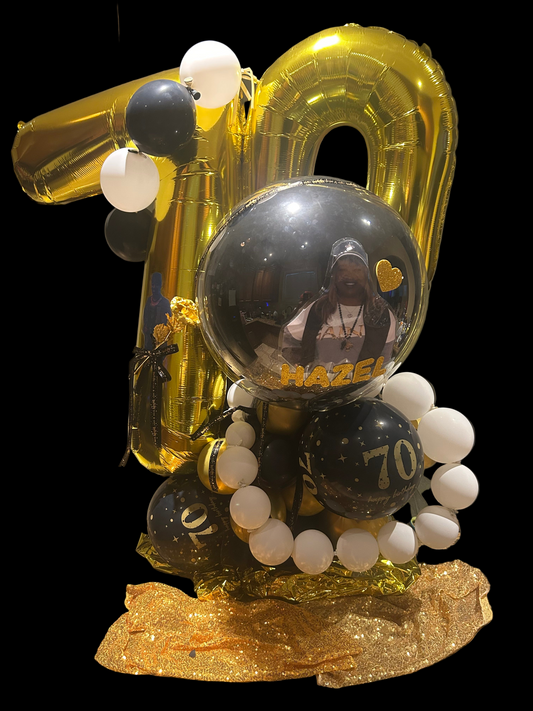 Decorative balloons with gold, black, and white colors on a countertop.