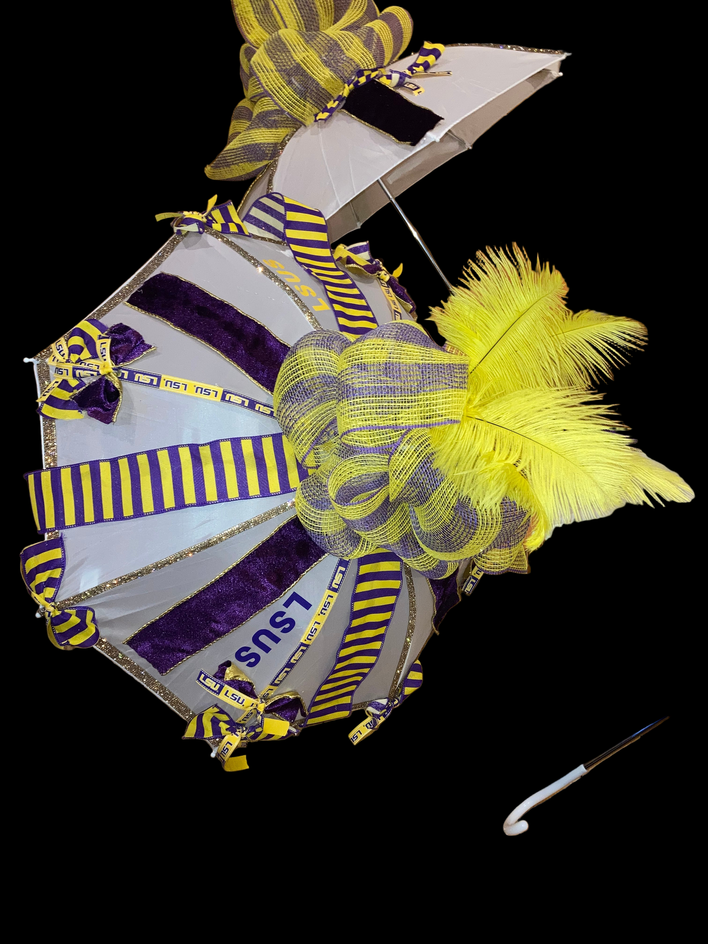 Decorative item with yellow feathers and purple ribbons on a wooden floor