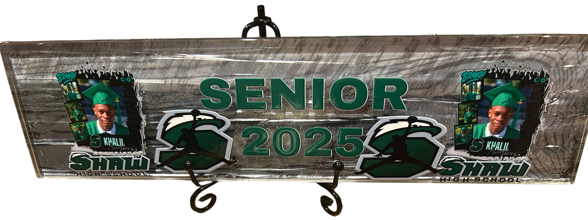 Metal plaque with 'Senior 2025' text and images on a granite surface